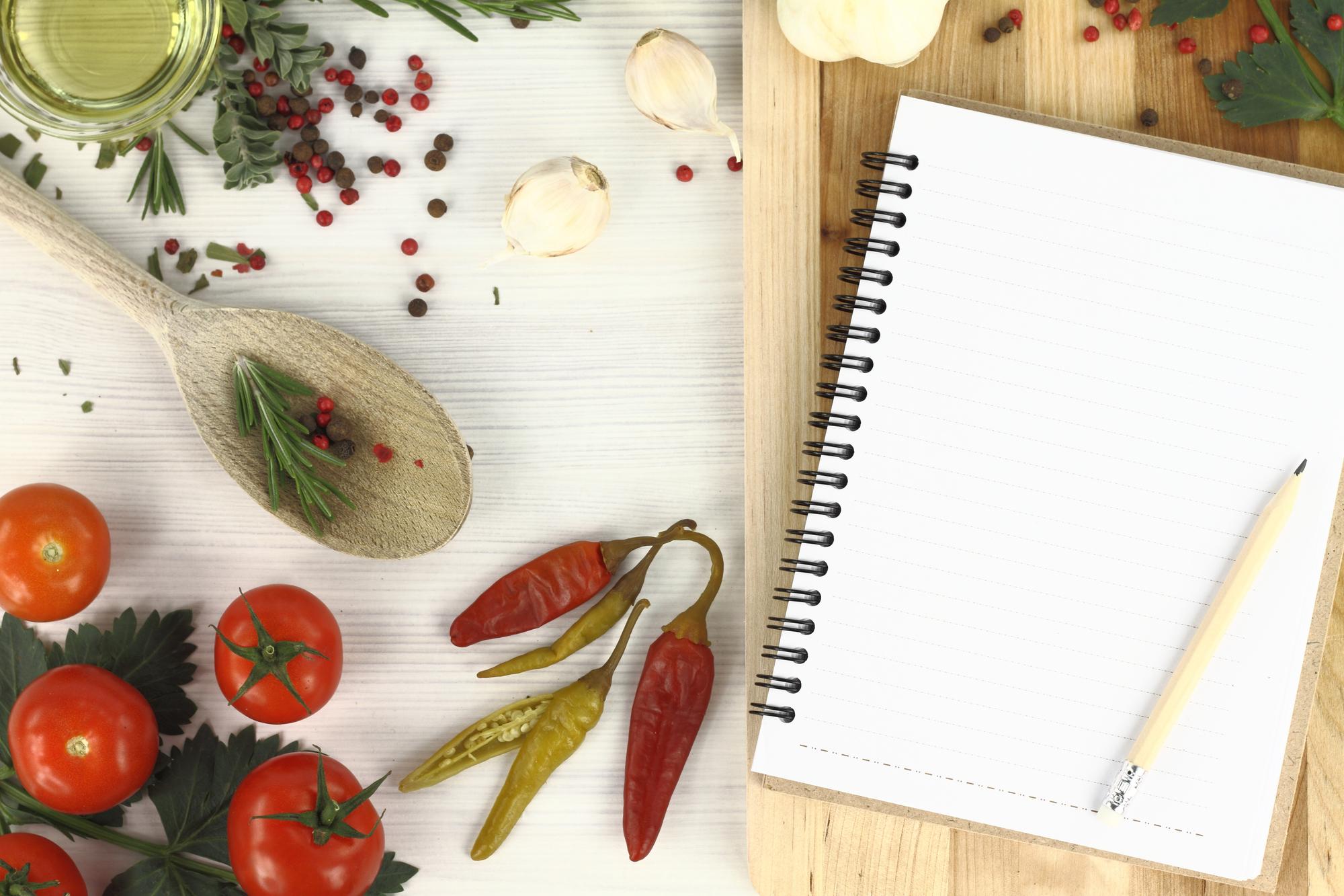 Mesa con ingredientes frescos y cuaderno de recetas